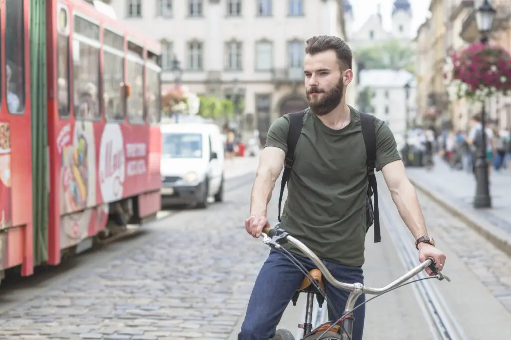 A male college student biking around during his European trip to save money on transportation 
