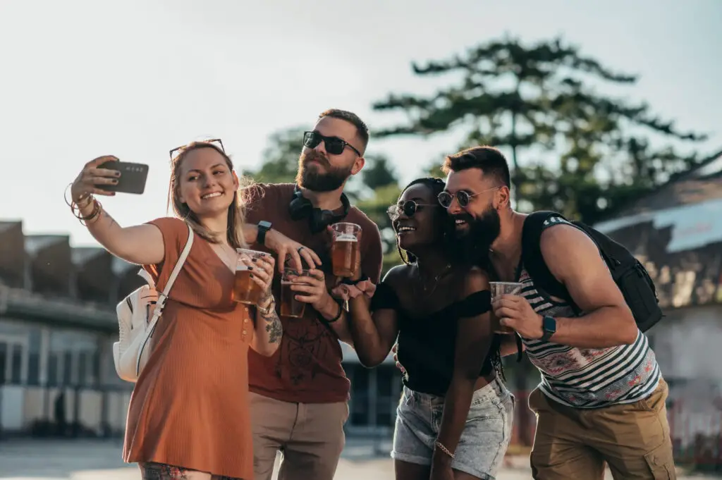A group of college friends holding beer while taking a selfie around Savannah, Georgia