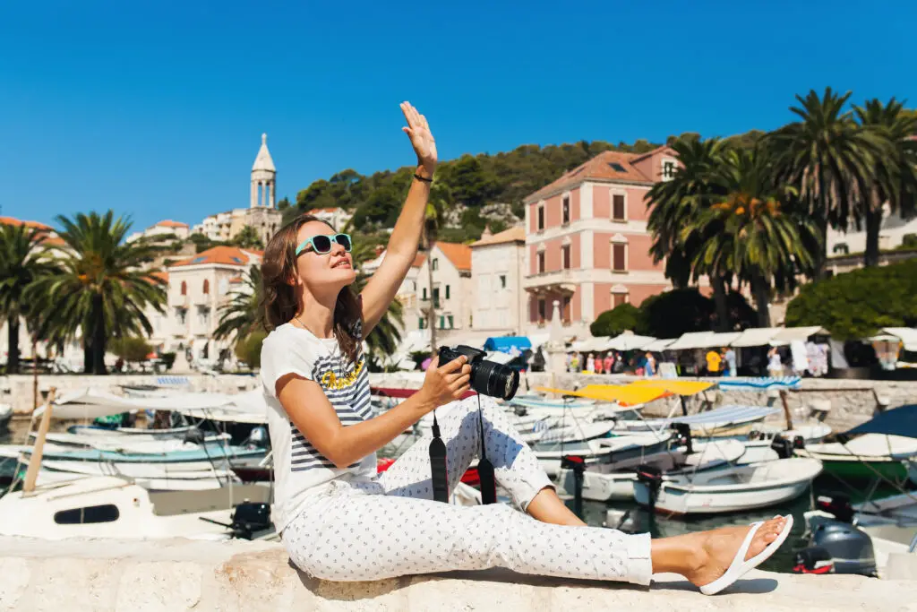 A female college student taking pictures of her cheap travel destination's attractions
