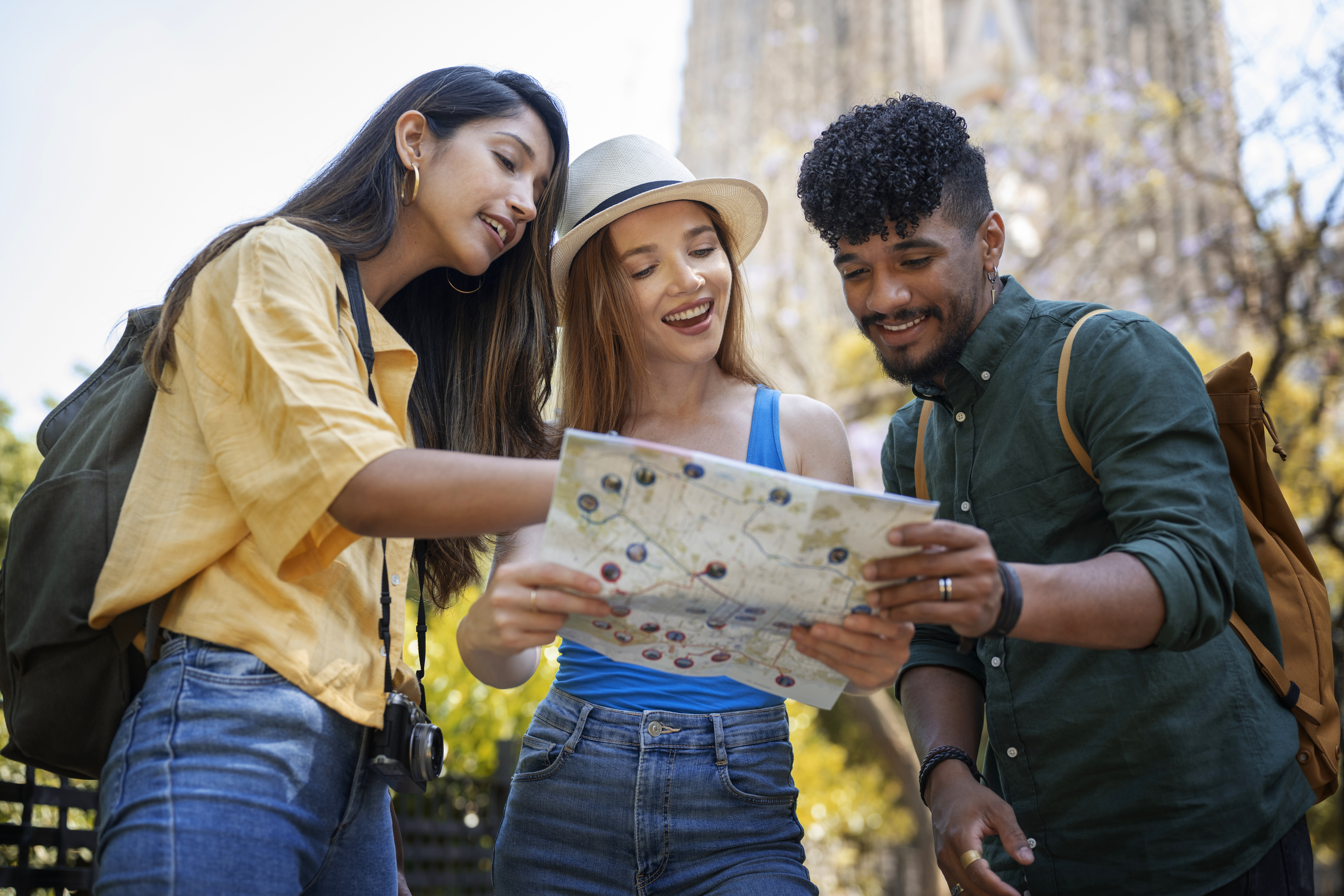 Three college students consulting a city map during their cheap travel to a European country