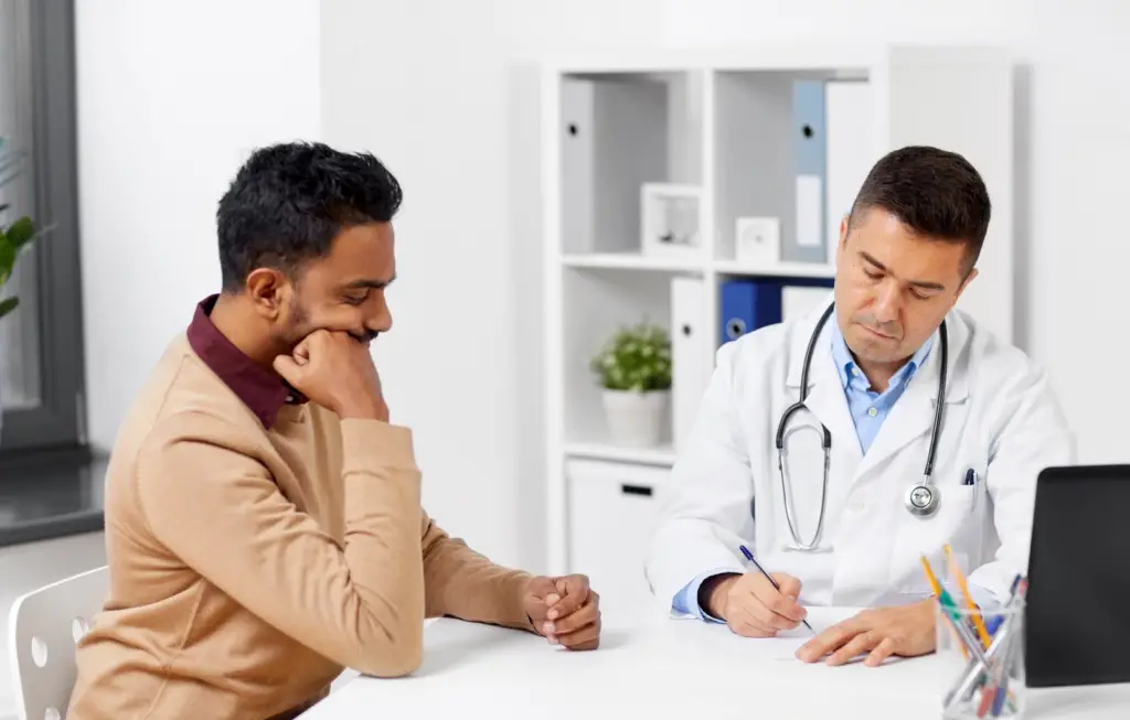 a male international college student consulting with a doctor about his plan coverage