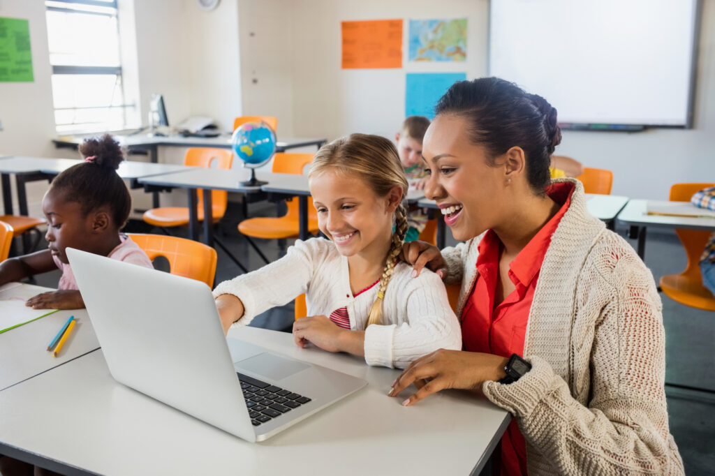 a female college student working as a teaching assistant is teaching her young student in class