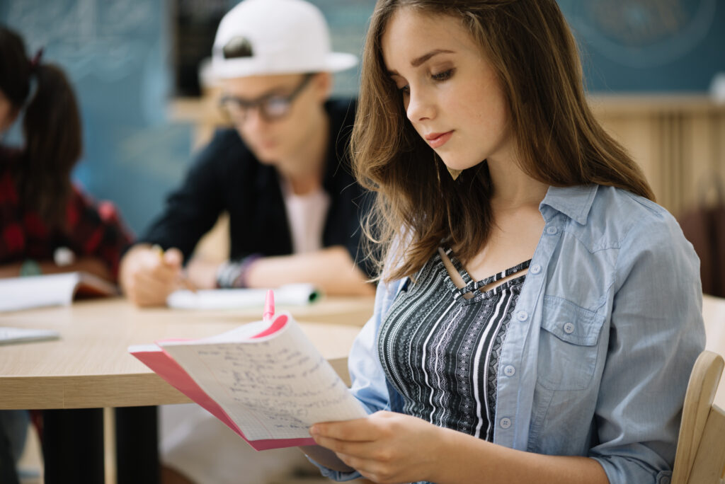 A female college freshman applying a note-taking method to record key lessons in class