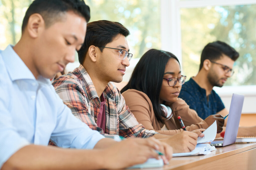 Four college students of different ethnicities apply different note-taking methods during class