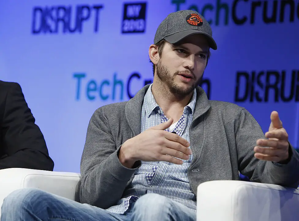 Ashton Kutcher wearing a cap while speaking at the 2013 TechCrunch Disrupt NY event