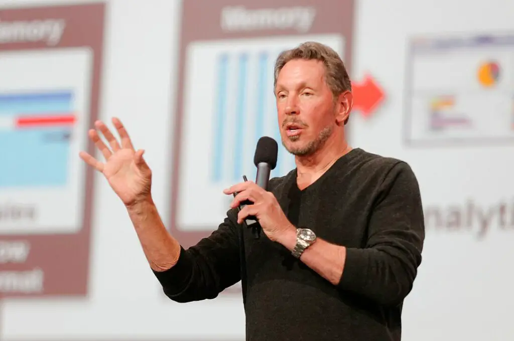 Larry Ellison wearing a black v-neck and giving a speech during a 2013 event