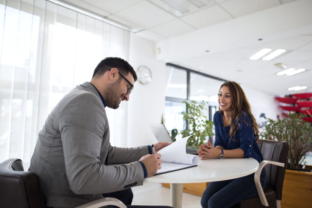 A smiling female college graduate complimented by the hiring manager for good written and oral communication skills