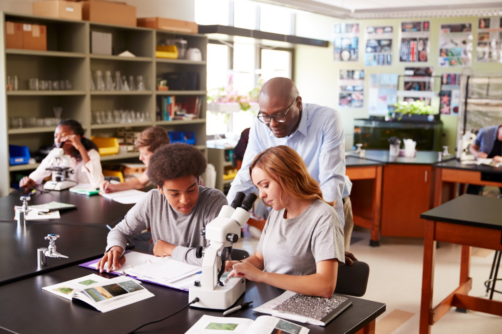 a high school teacher assisting a female and male high school student in AP class