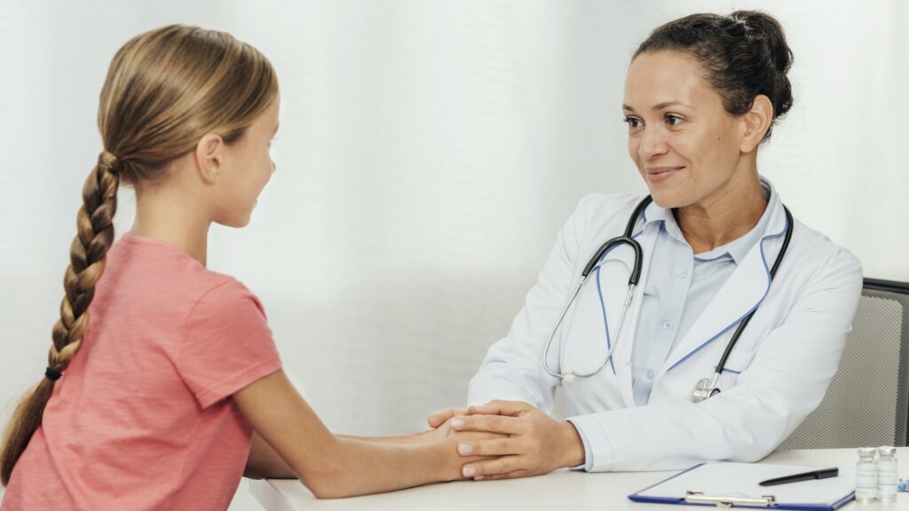 A female pediatrician in her 30s reassures a child after coming down with an illness