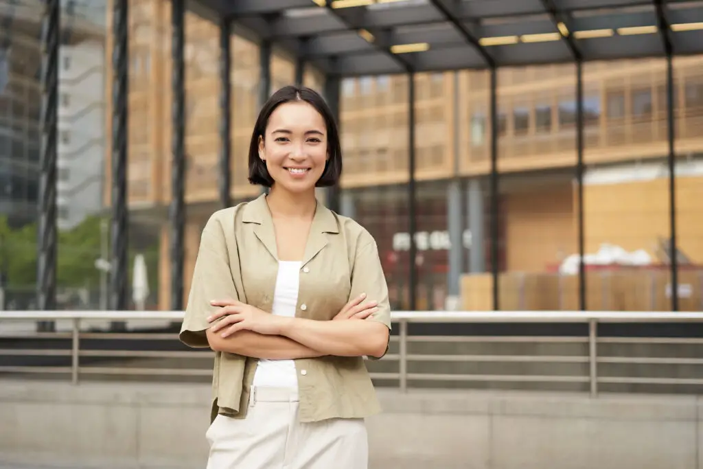 A smiling Asian female college student poses for a leadership campaign in a student organization 