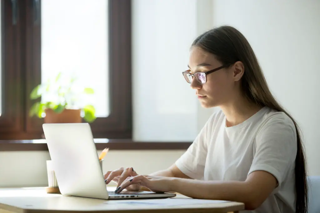 A female high school senior is typing "finding scholarship tips" in her online research