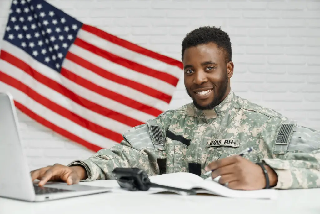 A black male soldier smiling while taking online college classes using military benefits