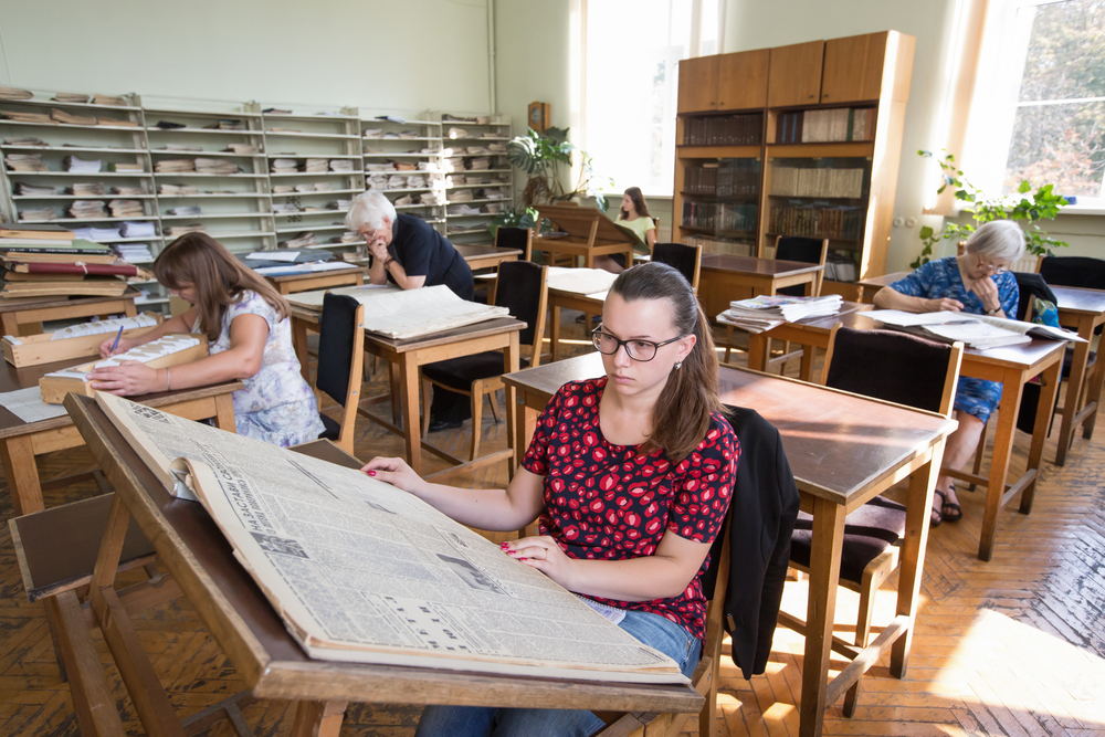 a female college student finding essay sources beyond journal and books such as newspaper records