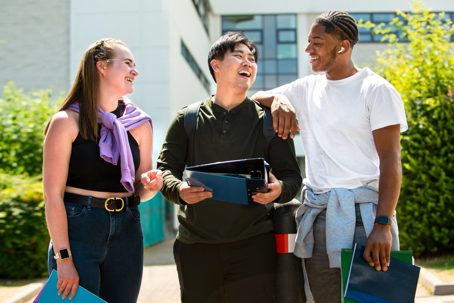 three multicultural students talking outside of the community college