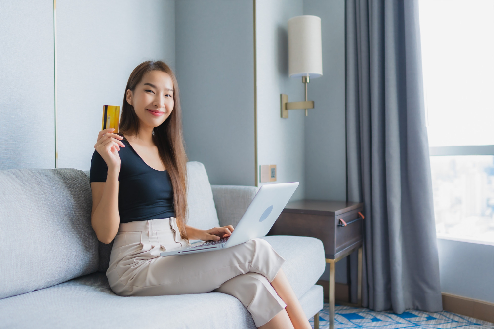 A female college student smiles as she's about to check her monthly credit card statement and track her spending habits for her budget plan
