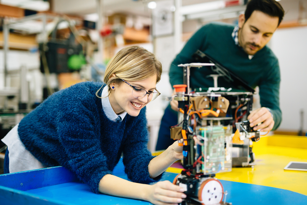 male and female college students working on robotics project in a lab