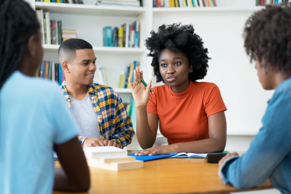 male and female college students discussing and solving a problem as one of the ways college prepares you