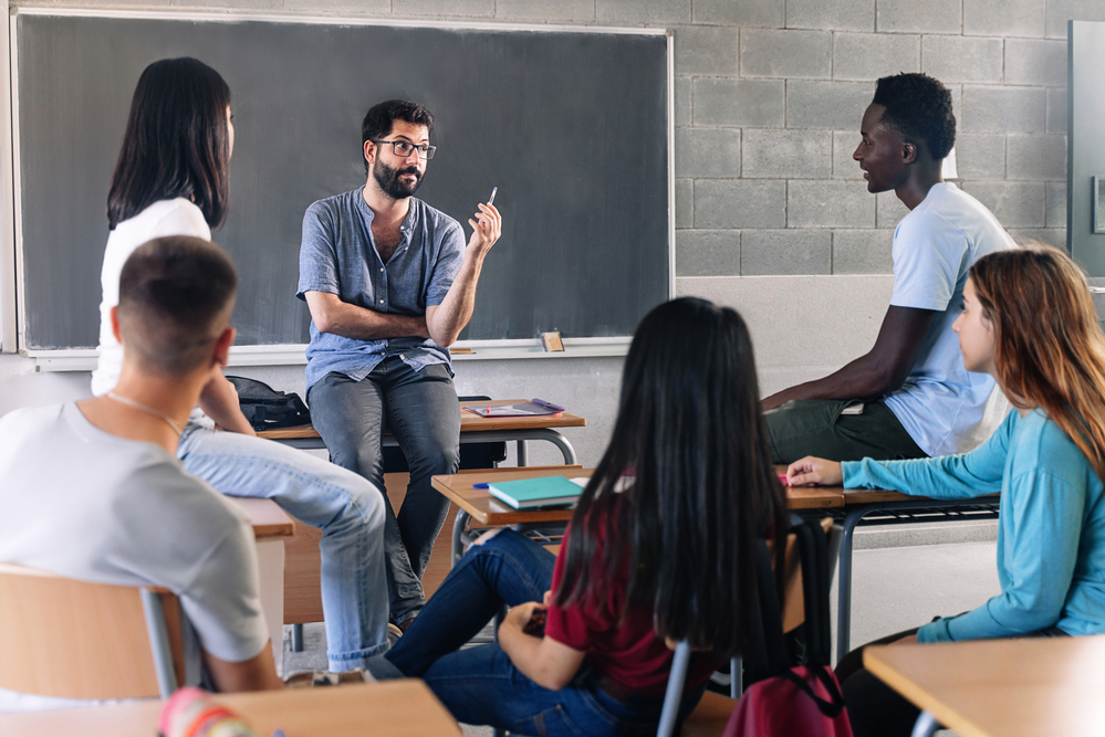 a group of male and female college students working together for a project inside a classroom