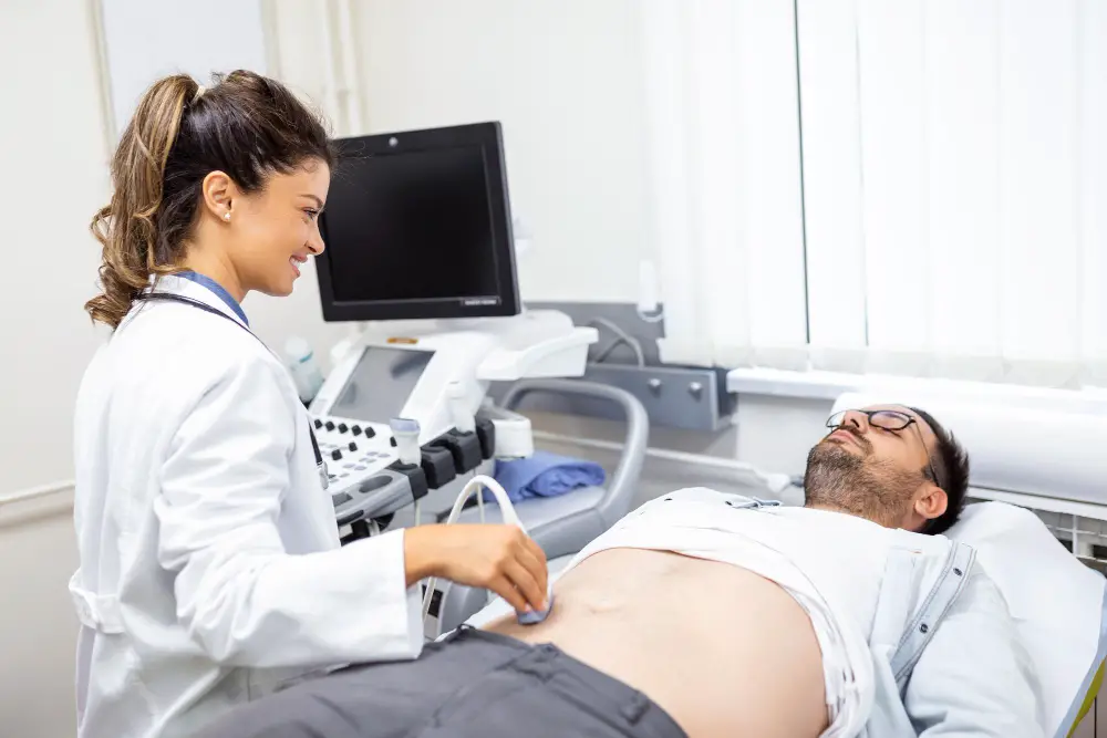 A female sonographer checks a male patient's stomach in the laboratory 
