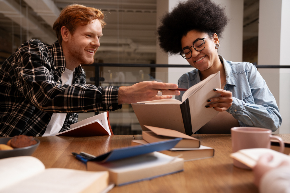 Two college students smiling while reading cases as they learn how to prepare for law school in college