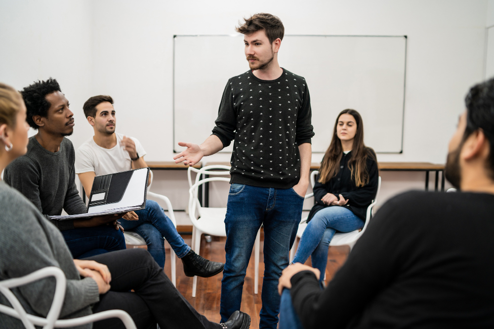 A male college senior presents a speech in his public speaking club as part of his preparation to attend law school