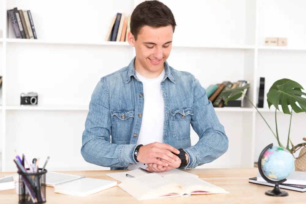 Male college student sets the timer on his watch to finish reading a case as he learns how to prepare for law school in college