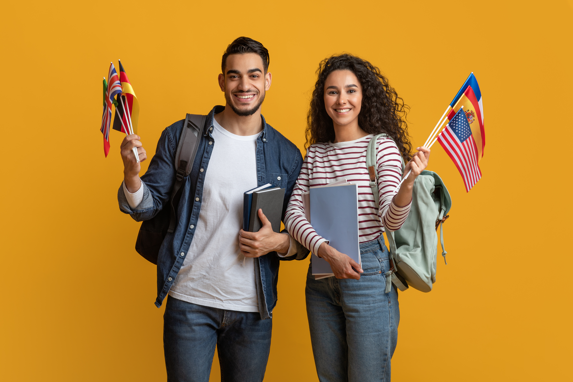 male-and-female-best-study-abroad-programs-students-holding-different-flags-and-books
