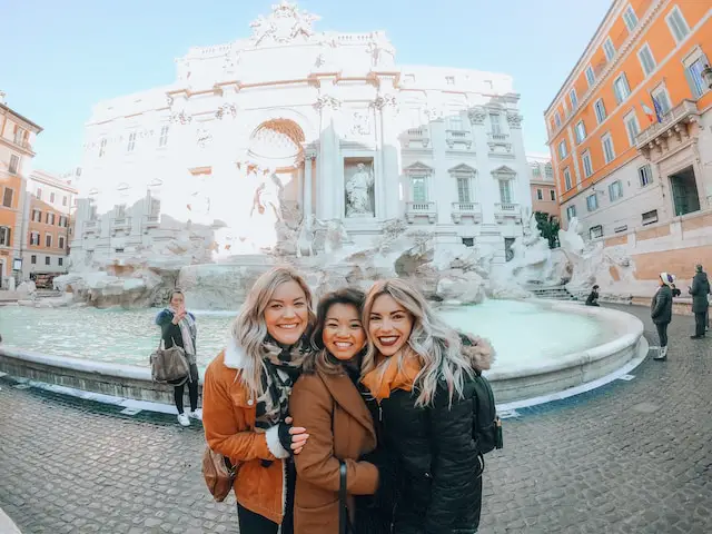 female-study-abroad-college-students-smiling-and-taking-photos-in front-of-the-Trevi-Fountain-in-Rome