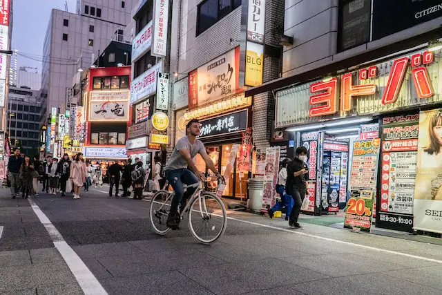 male-college-student-riding-a-bike-through-local-streets-of-Japan-for-his-study-abroad