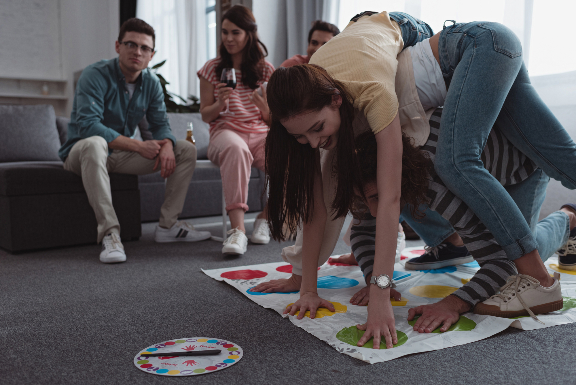male and female college members of the Childish Games Commission play twister
