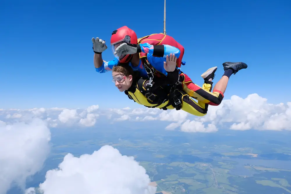 male and female college student skydive in tandem