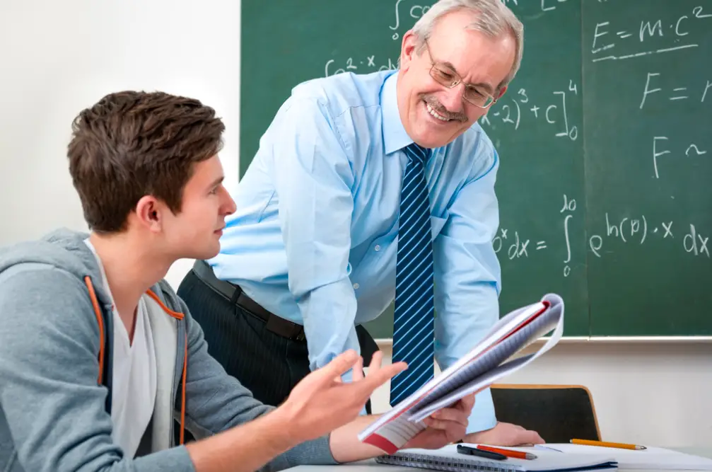 male college student with a male teacher in a classroom