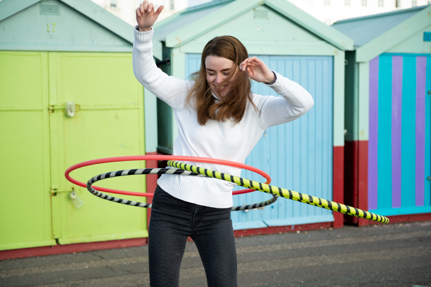 female college student playing with hula hoops outdoors