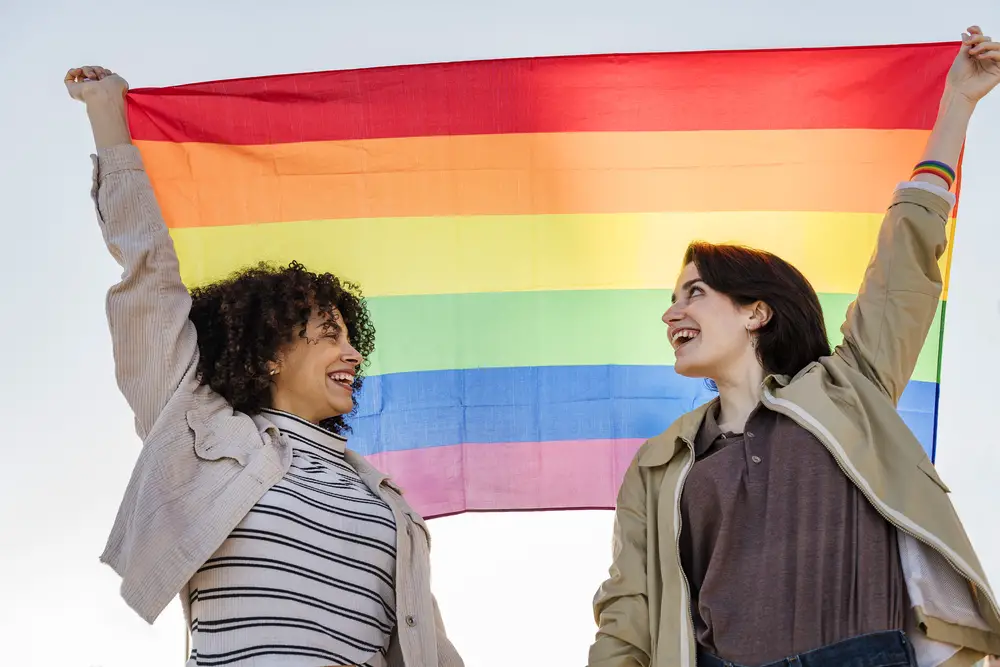 woman-with-non-binary-person-holding-an-lgbt-flag
