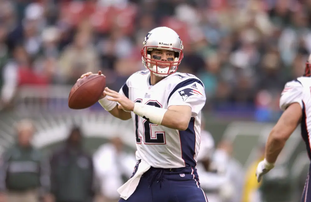 UMich graduate Tom Brady about to throw a football during NFL game season 