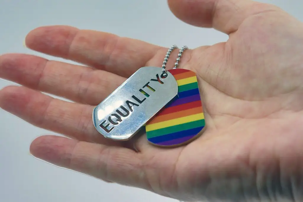 person-holding-rainbow-dog-tag-in-their-hand