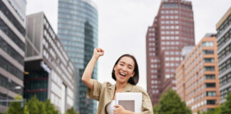 A happy Asian female college student pumps up her fist in joy after finding the perfect career choice