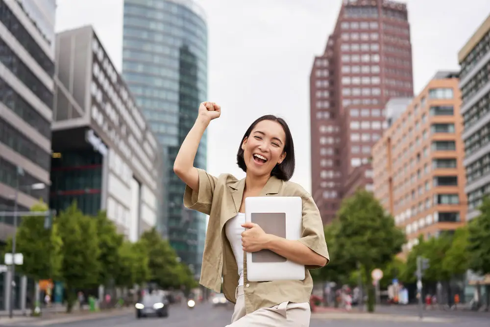 A happy Asian female college student pumps up her fist in joy after finding the perfect career choice