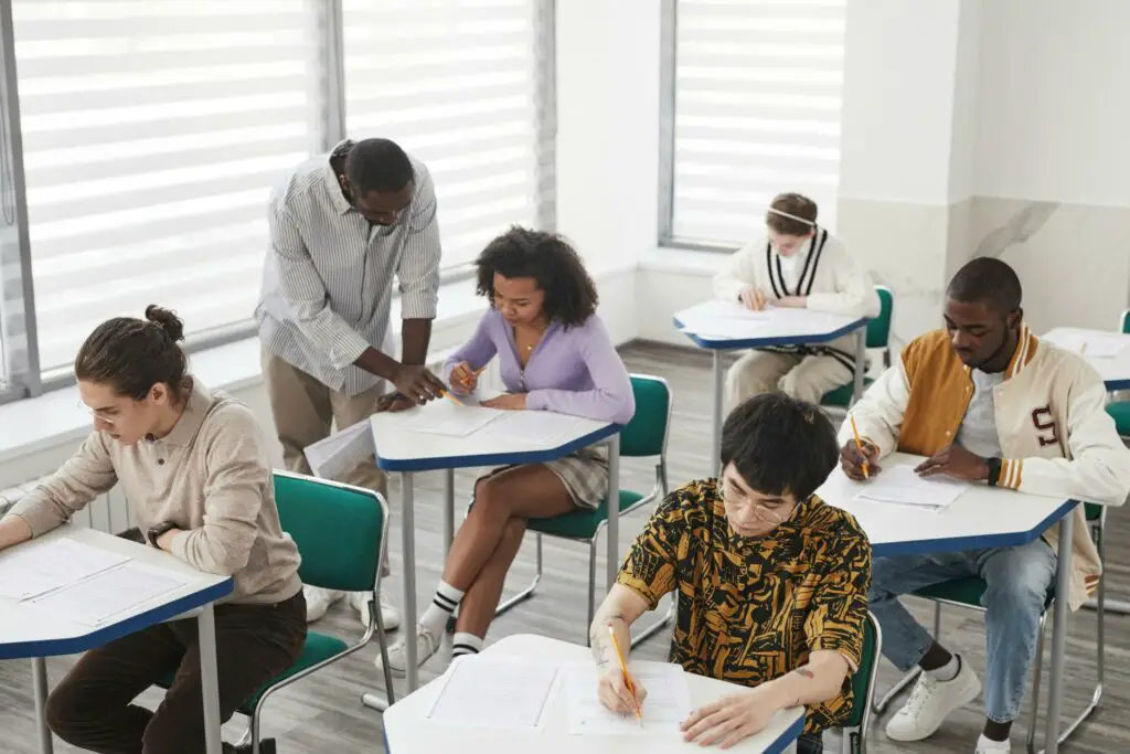 Multicultural students attentively seated at desks in a classroom, preparing for BAR exam through simulation