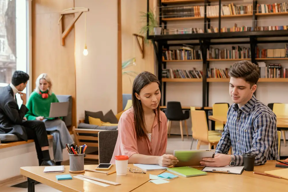 Four college students working on class requirements in the campus study space