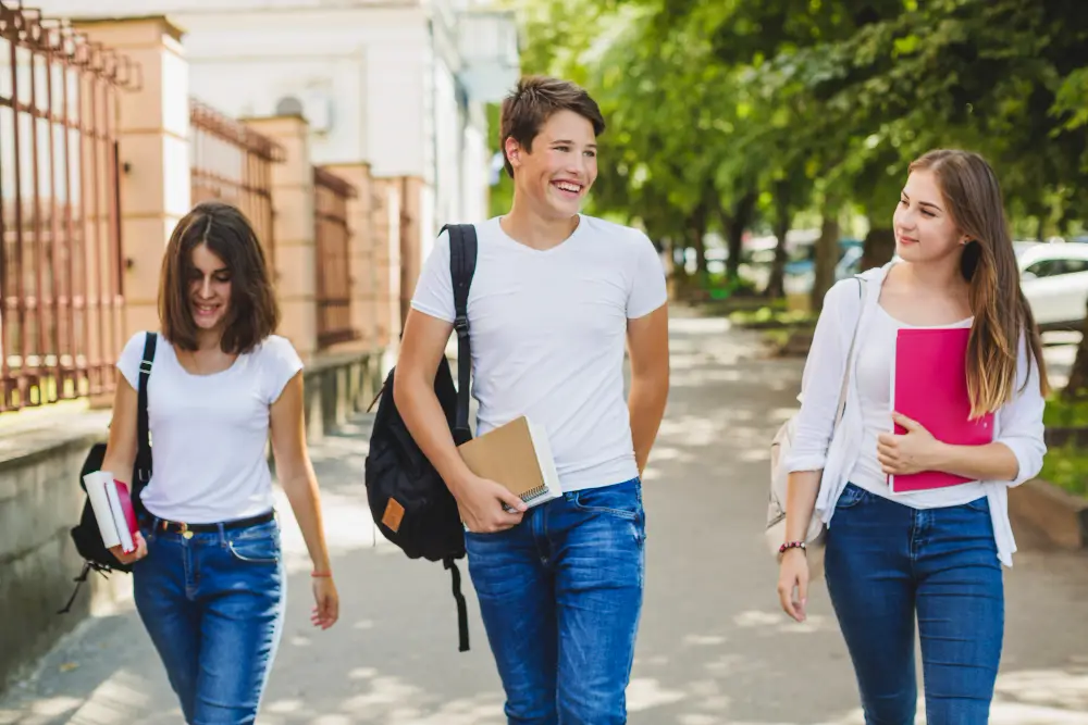 Three smiling college students walking along the streets as exchange students studying abroad