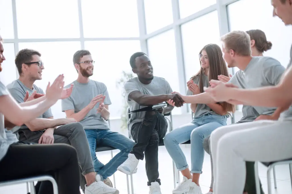 A diverse group of students sitting on chairs, having icebreakers to meet new college friends