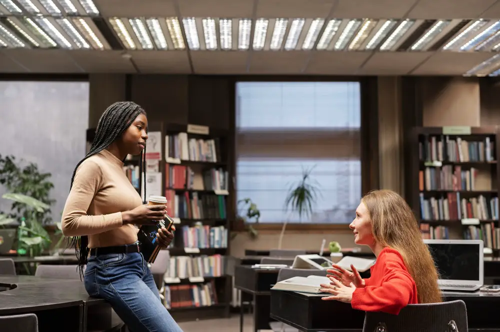 A female college student discusses with a post-graduate student about their research project