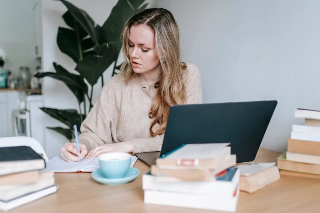 Female student studying with laptop and books on the desk