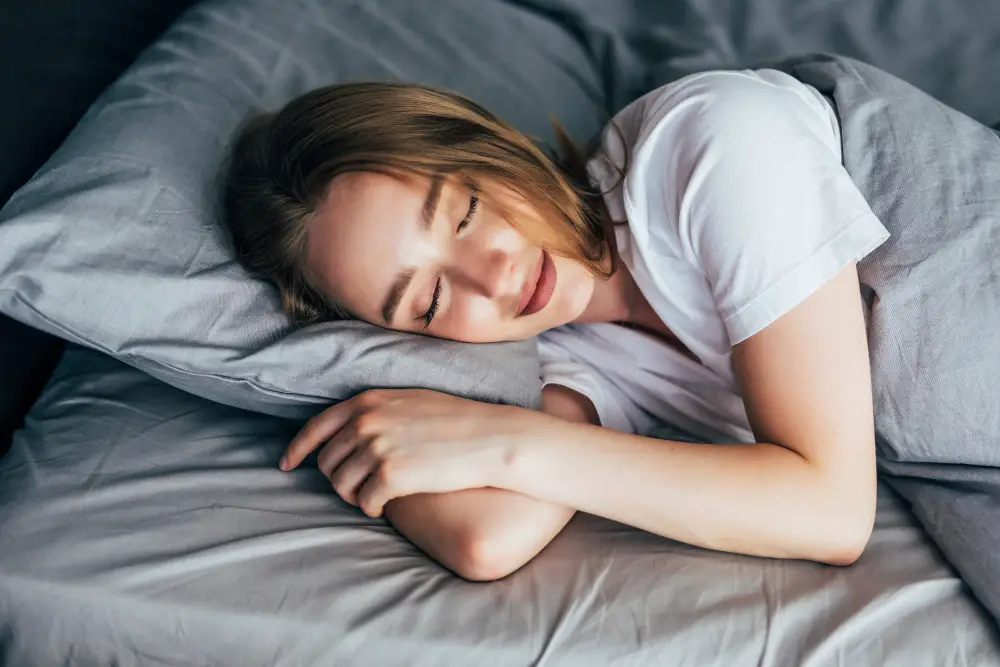 A female student sleeping peacefully in bed after following the ways to get good sleep in college