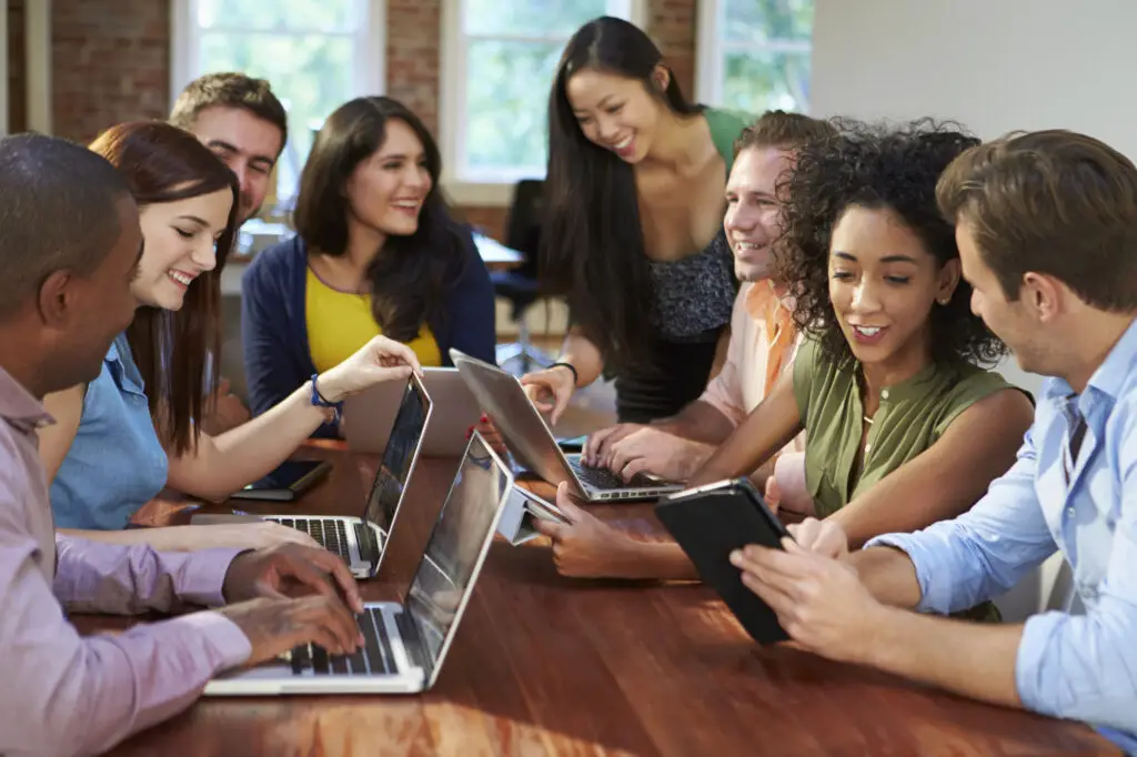 A diverse group of students collaborates around a table during college orientation