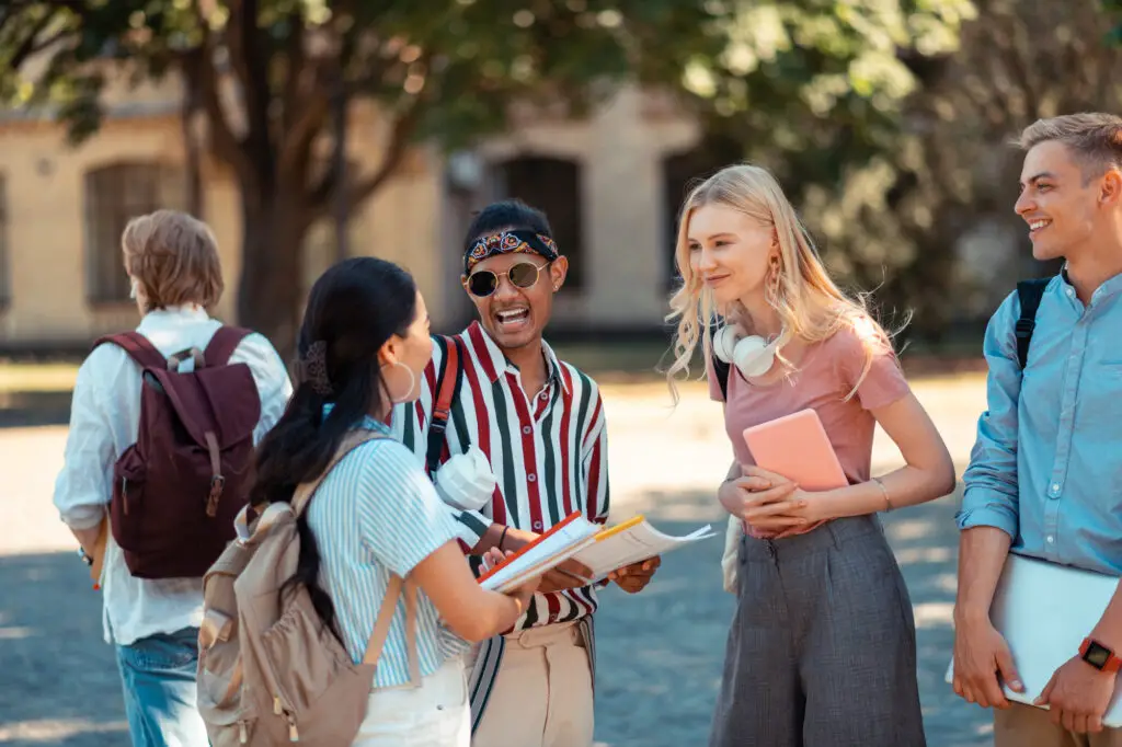 A diverse group of students engaged in a lively conversation while sharing ideas and laughter in a college orientation