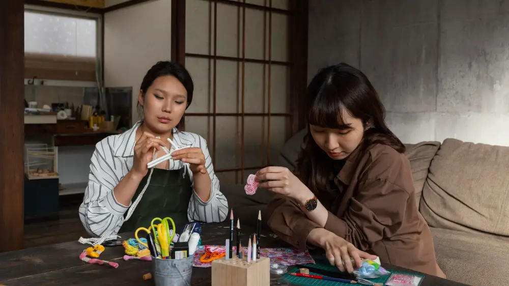 Two female high school graduates practice arts and crafts during a gap year program trip to Japan