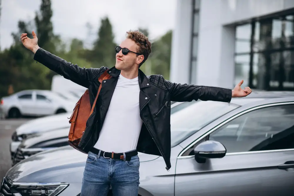 A fraternity member shows off his outfit and car within the school campus