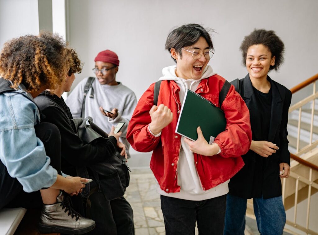 a group of diverse college freshman students excitedly walking the hallways of their university